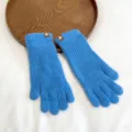Detailed shot of blue knit gloves with decorative cuffs, soft warm winter accessory. - One Size / Light Blue