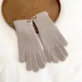 Detailed shot of solid color knit warm gloves, soft winter texture and cute leather patch. - One Size / Milk Tea