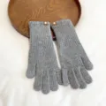 Detailed view of grey knitted warm winter gloves, soft texture and comfortable fit. - One Size / Gray