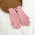 Detailed shot of women's pink ribbed knit gloves, warm and cozy winter accessory. - One Size / Pink