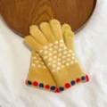 Detailed view of women's winter knit touchscreen gloves with cute heart patterns for warmth. - One Size / Yellow