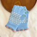 Detail shot of women winter warm knit touchscreen gloves with cute white heart patterns. - One Size / Blue