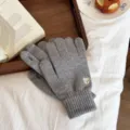 Close-up detail of grey knitted touch screen gloves with cute bear embroidery in cozy scene. - One Size / Gray