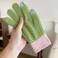Close-up detail of green and pink knitted touchscreen glove with cable knit pattern and cozy texture. - One Size / Green