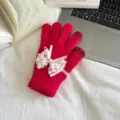 Detailed view of hot pink knitted touch screen gloves decorated with delicate white lace bow. - One Size / Red