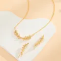 Set di gioielli con collana e orecchini a foglia di grano dorati vista dettagliata. - Oro