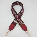 Vista dettagliata della tracolla di ricambio in jacquard colorato da 3,8 cm con pelle PU. - Gancio Argentato / Nero Rosso Bordeaux + Pelle Rosso Bordeaux