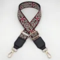 Detailed shot of retro ethnic embroidered wide bag strap with durable gold hardware. - Black Wine Red + Black Leather