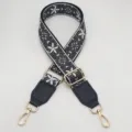 Close-up of retro ethnic embroidered wide bag strap with adjustable gold hardware. - Black Dark Grey + Black Leather
