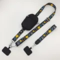 Colgante para móvil con estampado floral, correa ancha, bolsillo con cremallera y pestañas. - Bolsa Negra (Estilo Vertical) Gancho Plateado + Anillo / Flor Negra y Amarilla