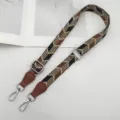 Verstelbaar geweven tasriem detail met stevige metalen haken en een stijlvol geometrisch patroon. - Zwart Bruin met Cognackleurig Leer