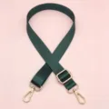 Detailopname van donkergroene nylon vervangende tasband met verstelbare gouden metalen gespen. - Donkergroen