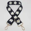 Vue détaillée de la sangle de sac large réglable à motif de marguerites noires et blanches. - Fleur Noire et Blanche