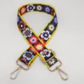 Détail de bandoulière de sac colorée à fleurs, large sangle avec accessoires en métal doré. - Crochet Doré / Fleur Multicolore
