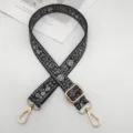 Vista detallada de la correa de bolso ancha con estampado floral étnico y herrajes dorados. - Estampado Floral Negro Pequeño