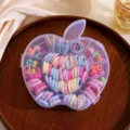 Detail view of a cute apple-shaped clear storage box filled with colorful elastic hair ties. - Apple Boxed