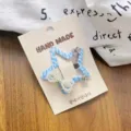 Primo piano dettagliato di un fermaglio per capelli a stella blu a quadri con fiocco di perle. - Forcina Stella Blu Singola