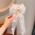 Detailopname van zoete tule strik haarclip met parelkwastjes en glinsterende hartjes. - Lichtcyaan Lint Strik Haarspeld