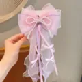 Vista dettagliata della forcina per capelli con fiocco di perle e nastri in organza da fiaba. - Fermaglio per capelli con fiocco viola
