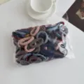Vista dettagliata di elastici per capelli colorati in busta trasparente su sfondo bianco pulito. - Morandi Confezione da 100