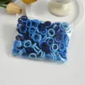 Close-up view of small blue seamless elastic hair ties in a clear plastic packaging bag. - Blue Series 100 Pcs