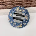 Fermaglio per chignon in tessuto floreale blu con pettini in plastica nera e ciondolo love in metallo. - Fiori blu