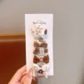 Vista dettagliata del set di graziosi fermagli per capelli a quadri per ragazze con fiocchi. - Design Fiocco Floreale / Confezione da 5