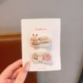Vista dettagliata di graziose mollette per capelli con pecorella e fiori su cartoncino bianco. - Pecora Floreale / Confezione da 2