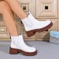 Women's white Chelsea boots with brown chunky lug platform sole, detail shot showing side gore. - 36 / White