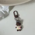 Quirky Natasha doll keychain, brown metal clasp, cute black baby figurine bag charm, trendy fashion accessory. - Black Bow