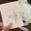 Close-up of cute lace hair clip with adorable bear design and sweet pink backing card detail. - Green