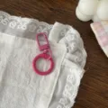 Dettaglio ravvicinato della chiusura a molla in metallo rosa e gancio portachiavi fai da te. - Rosso rosa