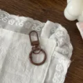 Primo piano dettagliato del moschettone a molla marrone e anello per accessori fai da te. - Marrone