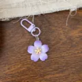 Detailed close-up of a sweet purple cherry blossom keychain, perfect stylish accessory gift. - Solid Purple