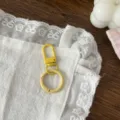 Detail shot of yellow painted spring gate ring and clasp set for DIY handmade keychains. - Yellow