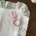 Close-up detail of pink spring ring keychain, metal clasp accessory for DIY crafts. - Pink