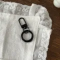 Dettaglio gancio a molla in metallo nero e anello rotondo, perfetto per accessori portachiavi fai da te. - Nero