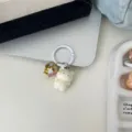 Close-up detail of a cute white cat keychain charm with glitter pendant, stylish accessory. - White Cat