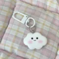 Cute white cloud keychain with pink blush and smiling face pendant on plaid background. - Smile