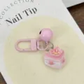 Close up of cute pink cherry blossom cake keychain pendant with bell and clasp detail. - Triangle Cake