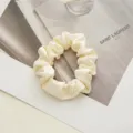 Elegant cream satin hair scrunchie detail view, soft shiny fabric gentle on hair, perfect for daily styling. - Off White