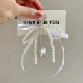 Close-up detail shot of elegant pearl bow keychain with silver heart pendant and ribbon trim. - White Bow - Heart Clasp