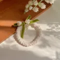 Elastico per capelli bianco con fiocco in velluto verde e ciondolo giglio, stile bosco. - Elastico per capelli / Bianco avorio