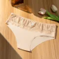 Detail view of women low-waist breathable lace panties with soft fabric and elegant floral trim. - S / Bottoms / Nude