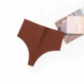 Detail view of women's seamless high-waist solid color soft athletic invisible thong panties. - Coffee Brown