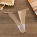 Vista dettagliata di un perizoma minimalista color nudo con spalline molto sottili. - Taglia M / Caffè