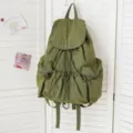 Detailansicht des waschgrünen Stoffrucksacks mit praktischem Kordelzug und Taschen. - Armeegrün