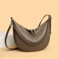Detailansicht der braunen Leder Halbmond Umhängetasche mit grober Kette und Reißverschluss. - Khaki