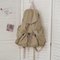 Nahaufnahme eines lässigen khakifarbenen Rucksacks aus Waschlappen mit Kordelzug und Klappe. - Khaki