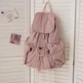 Freizeitorientierter Rucksack im Detail mit Kordelzug und praktischen Vordertaschen. - Rosa